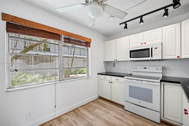 kitchen with a healthy amount of sunlight, light hardwood / wood-style floors, white appliances, and tasteful backsplash