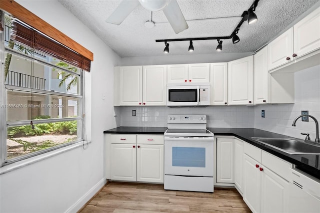 kitchen featuring ceiling fan, light hardwood / wood-style floors, tasteful backsplash, white appliances, and white cabinets