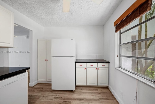 kitchen featuring light hardwood / wood-style floors, white appliances, and white cabinetry