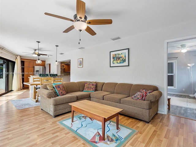 living room with light wood-type flooring and ceiling fan