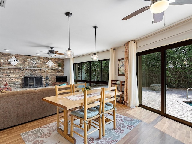 dining room featuring light hardwood / wood-style floors and a brick fireplace