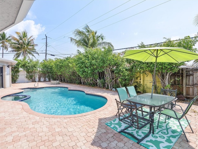 view of pool with outdoor dining space, a patio area, a fenced backyard, and a pool with connected hot tub