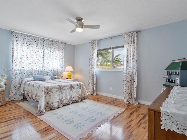 bedroom featuring a ceiling fan, baseboards, and wood finished floors