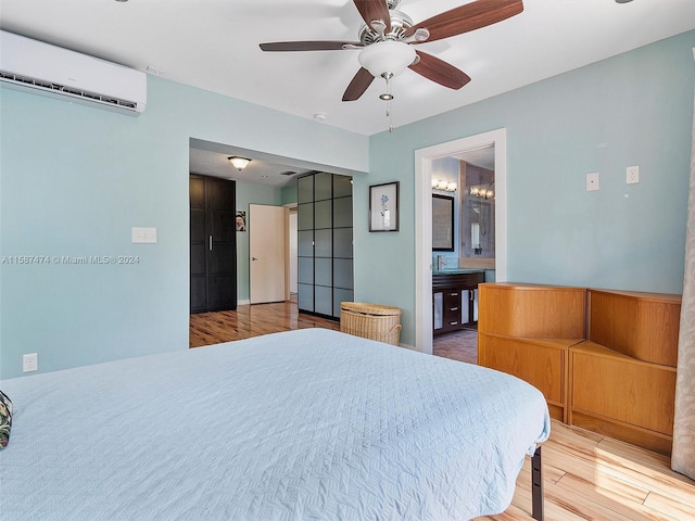 bedroom featuring ensuite bath, ceiling fan, a wall mounted AC, and wood-type flooring