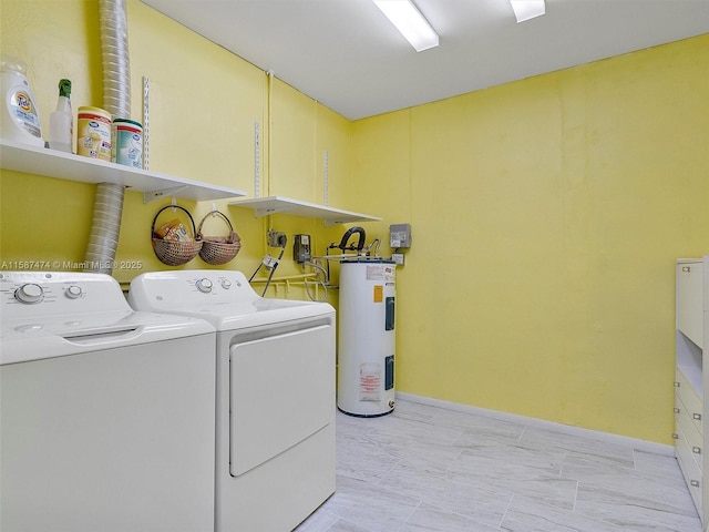 laundry area with water heater, laundry area, washing machine and clothes dryer, and baseboards