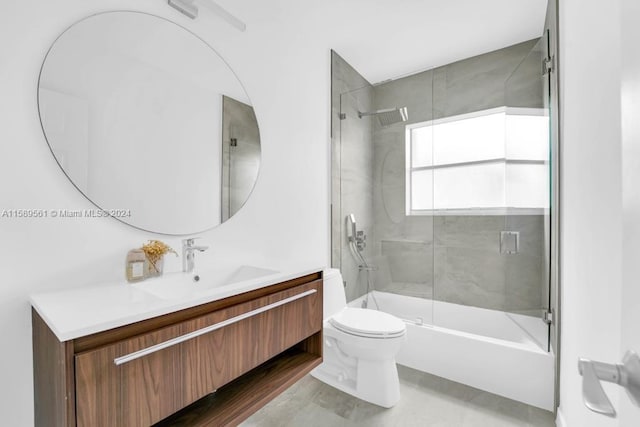 full bathroom with tile floors, combined bath / shower with glass door, oversized vanity, and toilet