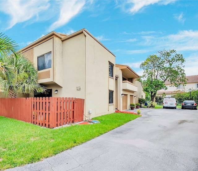 view of property exterior featuring a balcony and a yard