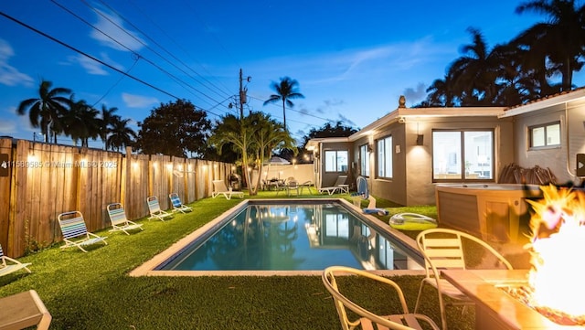 view of pool with a fire pit and a lawn