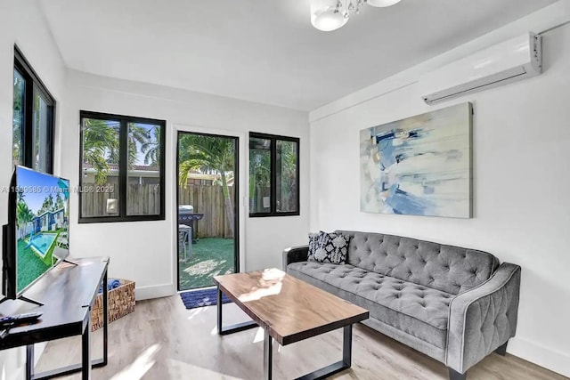 living room featuring light hardwood / wood-style floors and an AC wall unit