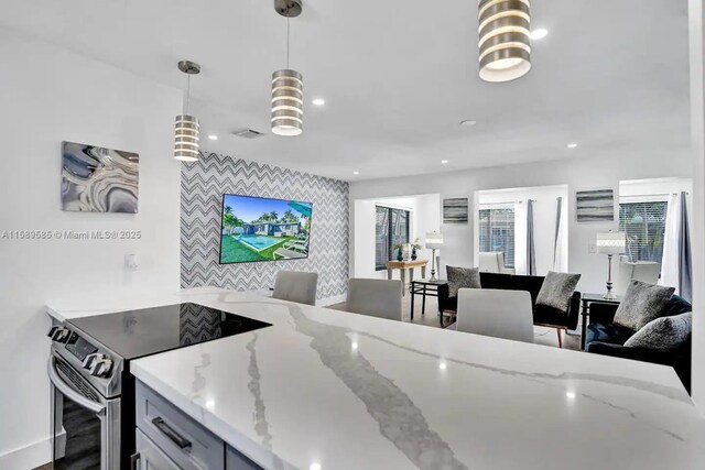 kitchen with appliances with stainless steel finishes, gray cabinetry, sink, light hardwood / wood-style floors, and hanging light fixtures