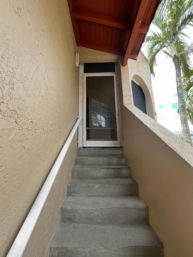 stairs featuring beamed ceiling and wooden ceiling