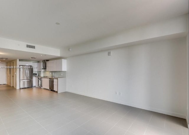 unfurnished living room with sink and light tile floors