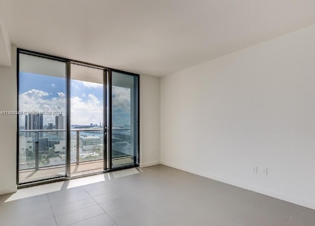 tiled empty room featuring plenty of natural light and expansive windows