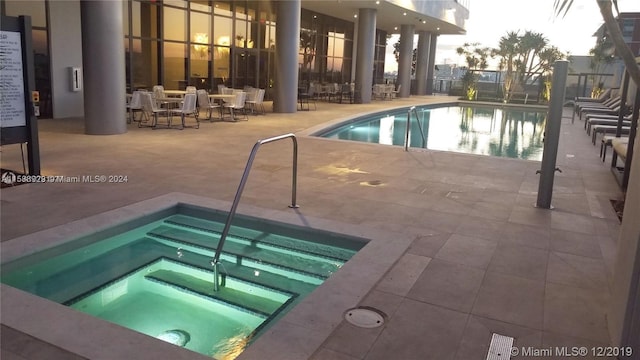 view of pool with a community hot tub and a patio area