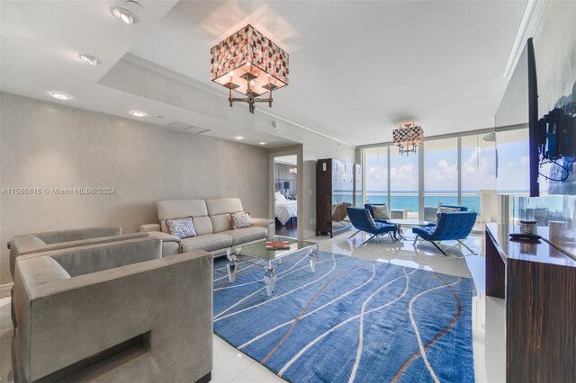 living room with a water view, ornamental molding, floor to ceiling windows, and tile patterned floors