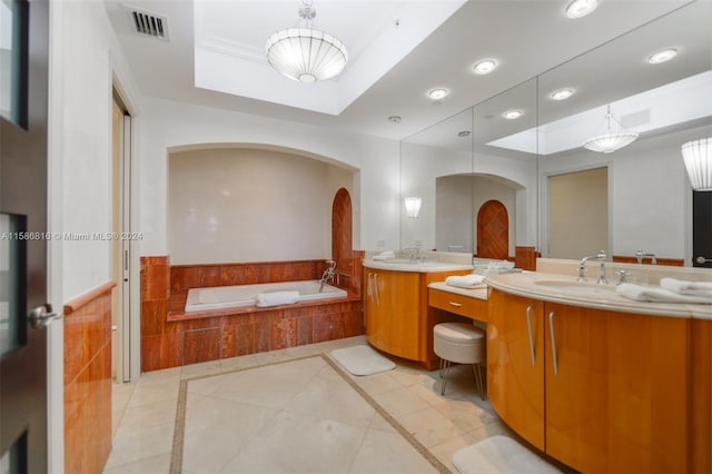 bathroom featuring a relaxing tiled tub, tile patterned floors, double sink vanity, and a tray ceiling