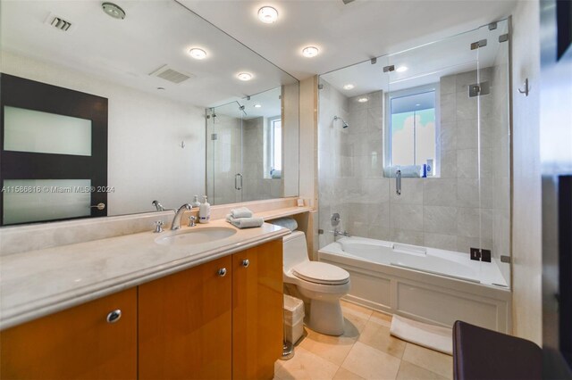 full bathroom with tiled shower / bath combo, tile patterned floors, toilet, and vanity