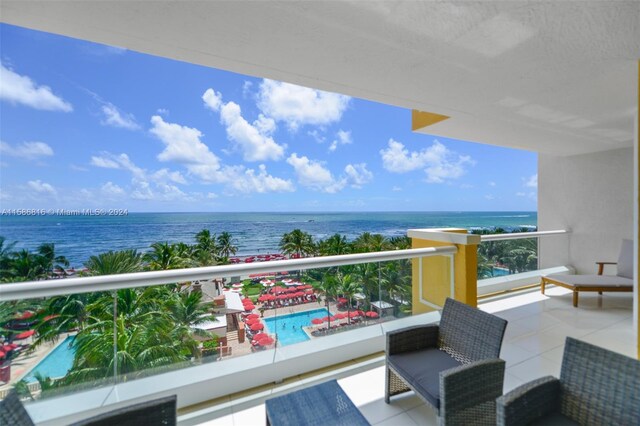 balcony with an outdoor living space and a water view