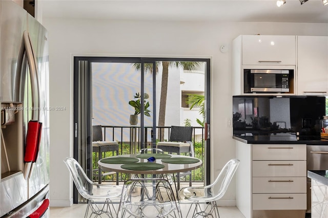 kitchen with white cabinets, stainless steel appliances, and decorative backsplash