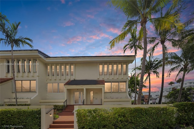 10090 Bay Harbor Ter Unit 10090, Bay Harbor Islands, FL 33154 - back of property at dusk featuring stairway and stucco siding