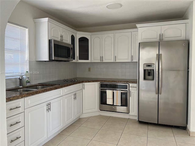 kitchen featuring stainless steel appliances, tasteful backsplash, white cabinets, sink, and light tile floors