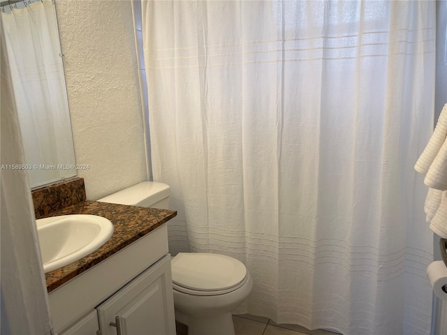 bathroom with tile floors, toilet, and vanity