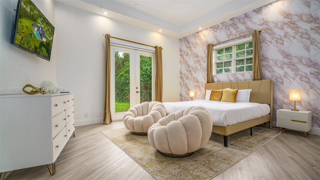 bedroom with access to exterior and light hardwood / wood-style floors