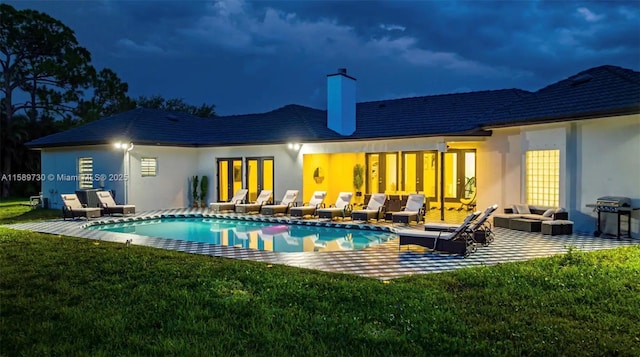 rear view of property with a yard and a patio