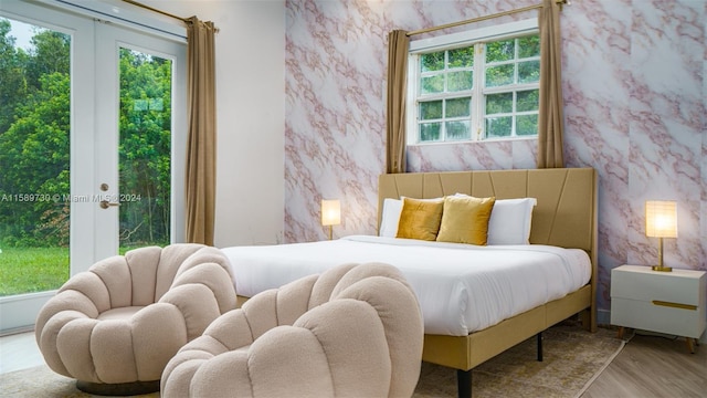 bedroom featuring light hardwood / wood-style floors, access to outside, and french doors