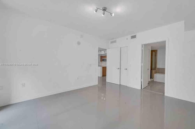 unfurnished room with concrete flooring