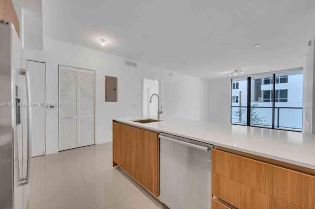 kitchen with sink, stainless steel dishwasher, and light tile floors