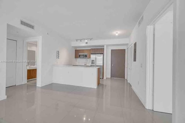 kitchen with track lighting, light tile flooring, and stainless steel appliances