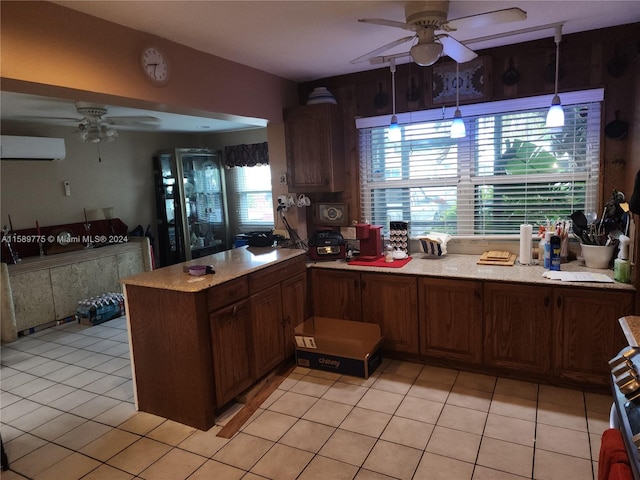 kitchen featuring ceiling fan, kitchen peninsula, decorative light fixtures, and light tile floors