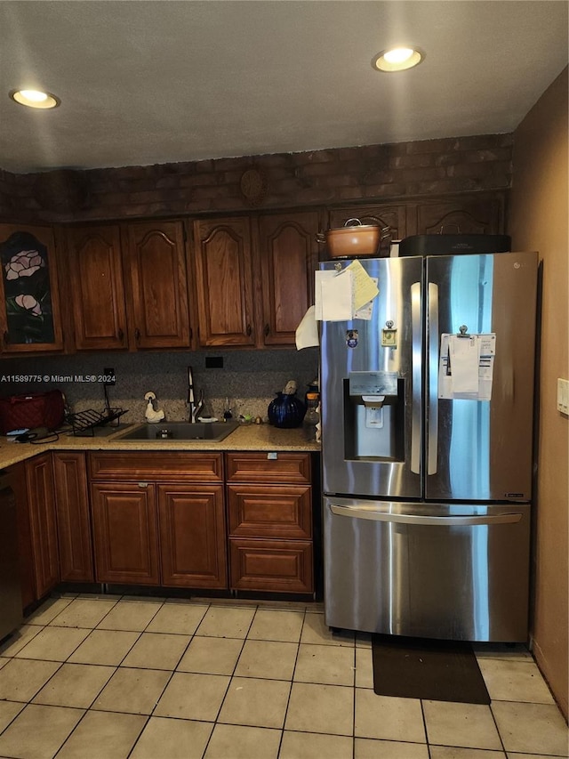 kitchen featuring sink, stainless steel fridge, tasteful backsplash, and light tile floors