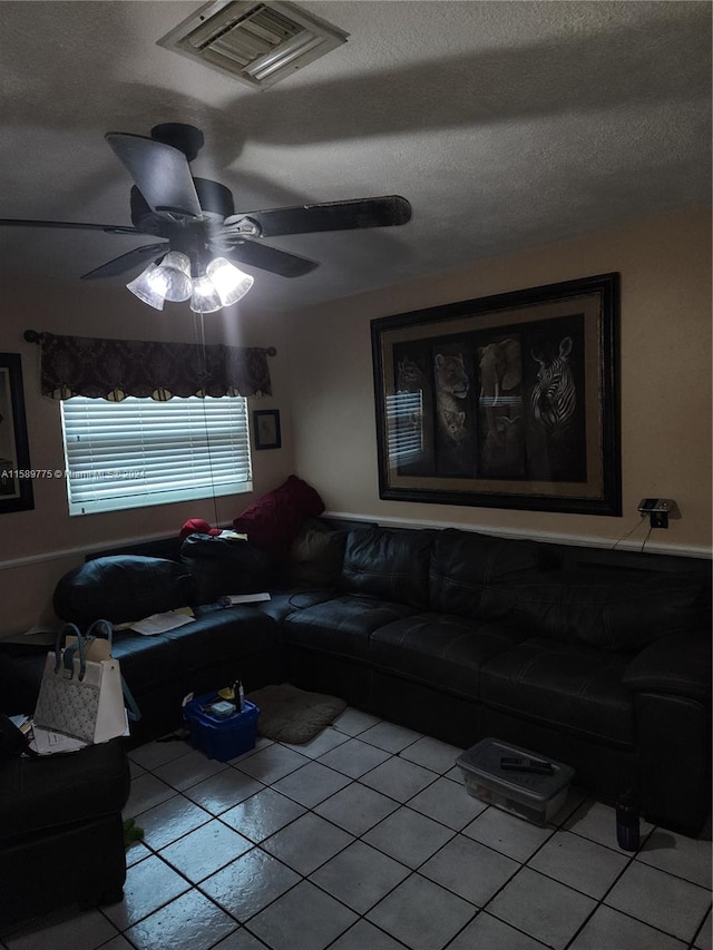 living room with a textured ceiling, ceiling fan, and light tile floors