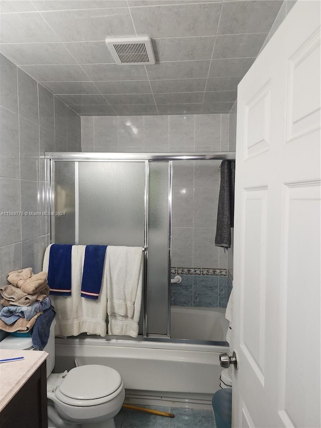 full bathroom with shower / bath combination with glass door, vanity, and toilet