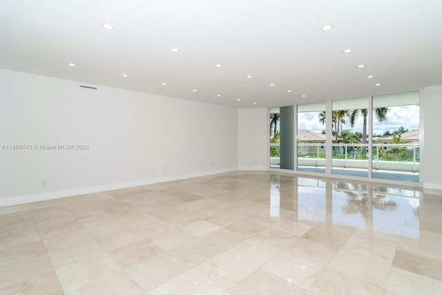 tiled empty room featuring expansive windows