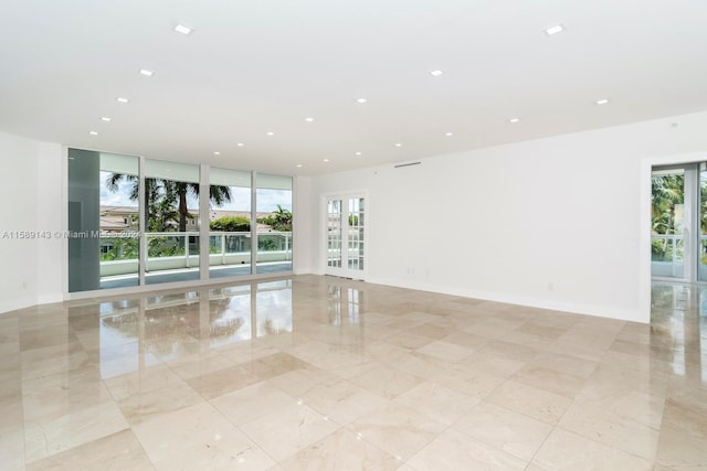 tiled spare room featuring floor to ceiling windows