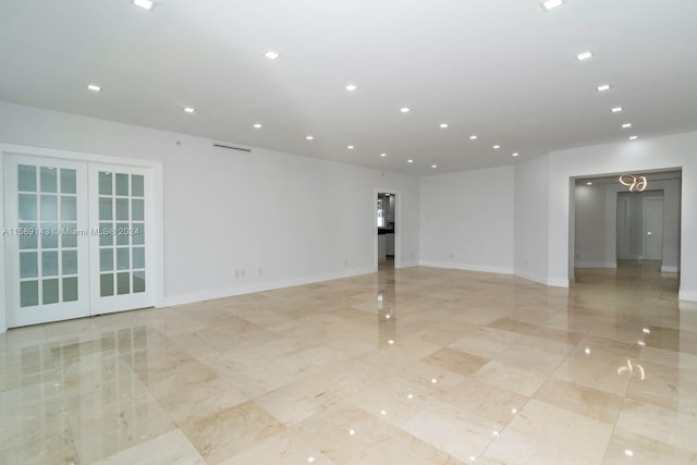 tiled empty room featuring french doors