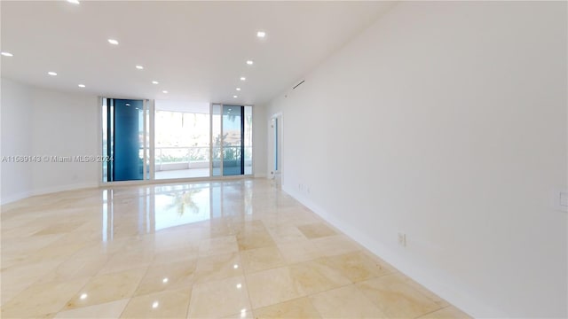 tiled spare room with floor to ceiling windows