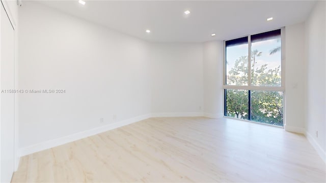 unfurnished room featuring light hardwood / wood-style floors and floor to ceiling windows