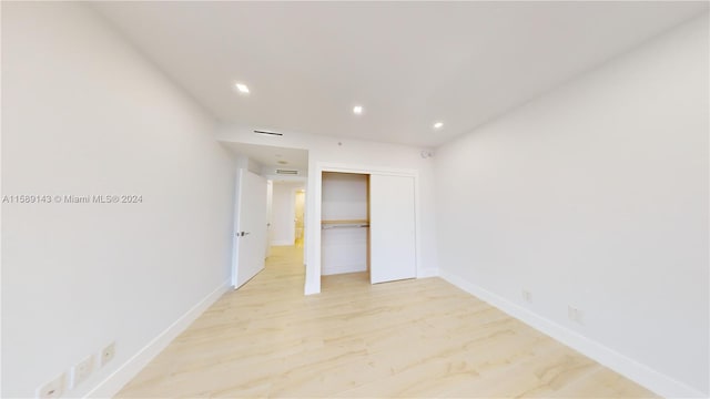 unfurnished bedroom with a closet and light hardwood / wood-style floors