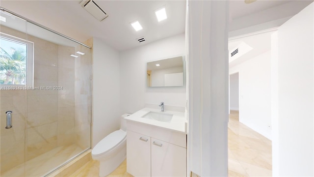 bathroom with tile floors, a shower with shower door, toilet, and vanity