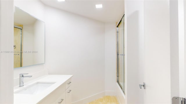 bathroom with shower / bath combination with glass door and vanity