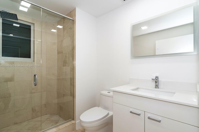 bathroom with a shower with door, toilet, and large vanity