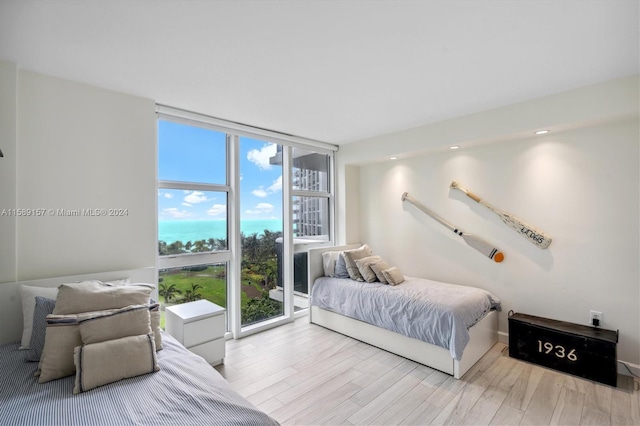 bedroom featuring light wood-type flooring and expansive windows