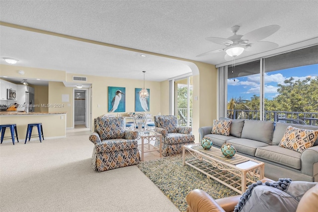 living room with a textured ceiling and ceiling fan