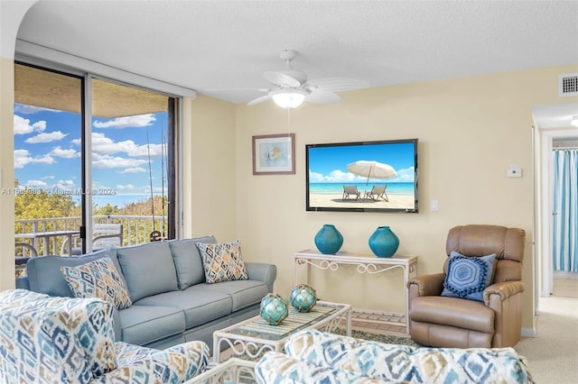 carpeted living room featuring a textured ceiling, plenty of natural light, and ceiling fan