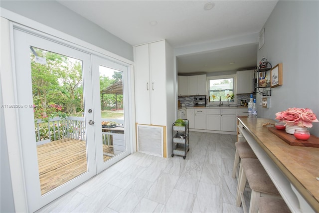 doorway to outside with plenty of natural light, sink, and french doors