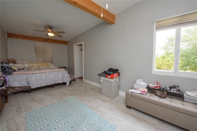 bedroom with beam ceiling, multiple windows, and ceiling fan